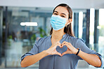 Covid, employee or woman with heart sign or hand gesture in office building showing support, love or safety. Compliance, coronavirus or happy worker in face mask with peace, wellness or care at job