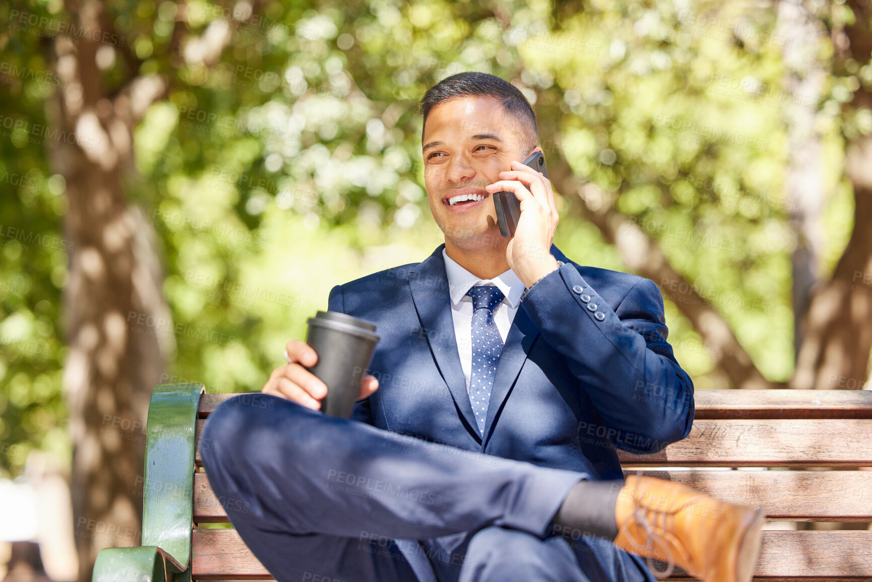 Buy stock photo Businessman, phone call and coffee talking on bench outdoor in morning for online conversation, virtual meeting or relax happy on corporate break. Man, sitting on bench and speaking on mobile in park