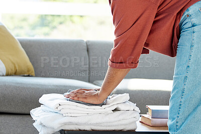 Buy stock photo Laundry, chores and hands of a woman with clothes, clean towels and clothing from the wash in the living room. Working, spring cleaning and cleaner with washing pile, housework and housekeeping