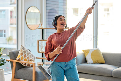 Buy stock photo Dance, radio or woman cleaning with music for singing or listening to a song with broom as a guitar at home. Relax, freedom or happy Indian girl cleaner streaming audio on headphones or housekeeping