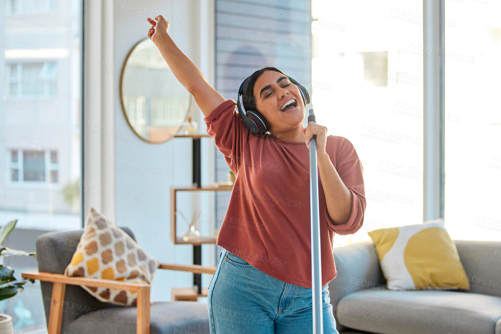Buy stock photo Music, headphones and woman singing while cleaning home, dancing and having fun. Singer, dance and female spring cleaning for hygiene holding broom like microphone, sweeping dust and streaming radio.