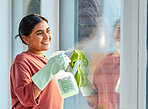 Glass, spray or woman cleaning a window with liquid soap or chemical product for dusty bacteria or germs at home. Cleaning services, dirty or happy Indian girl cleaner washing glass door with a cloth
