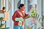 Woman, cleaning and window st home for dirt, dust and bacteria with a cloth and spray bottle for shine and clean view. Happy female cleaner or maid with a smile using chemical on apartment glass