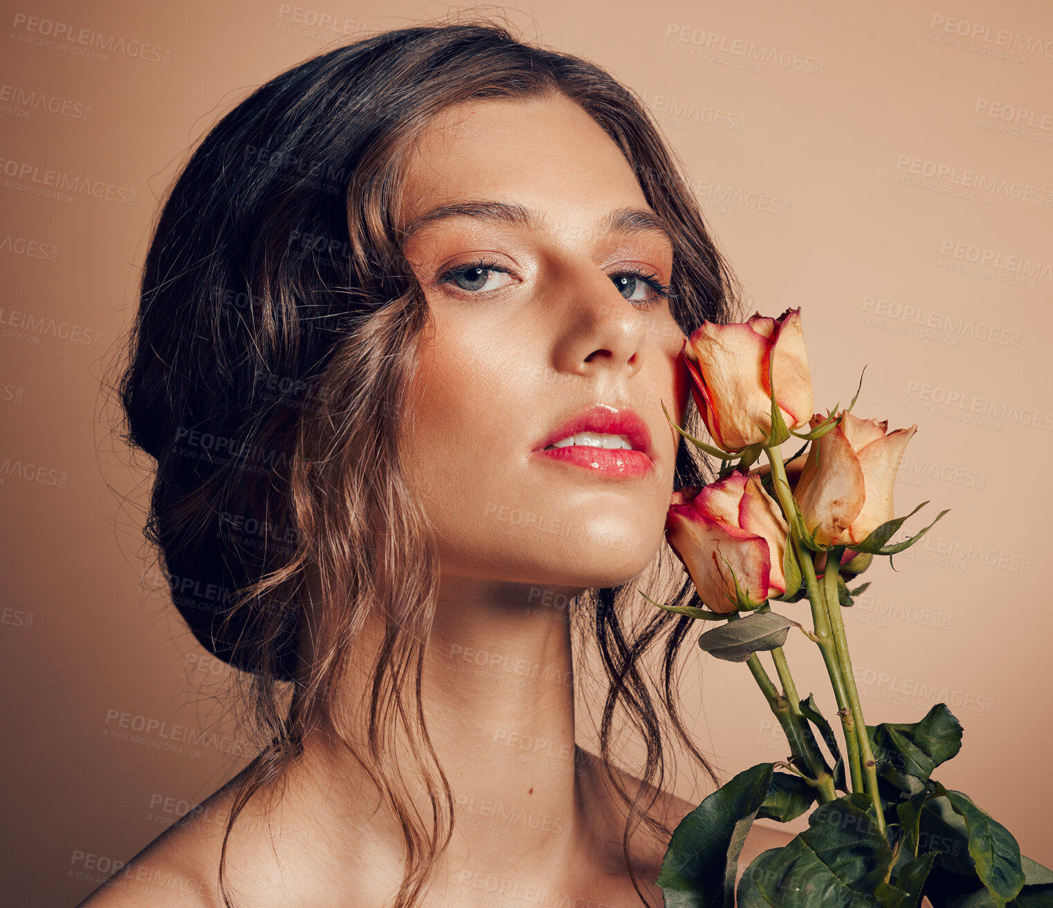 Buy stock photo Beauty, flowers and face of woman in studio for wellness, fashion and skincare on brown background. Makeup, cosmetics and female model with roses for beauty salon, natural self care and spa aesthetic