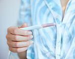 Pregnancy test, woman and hands check results of medical information at home. Closeup, fertility stick or family planning for maternity wellness, pregnant hormone or ivf healthcare treatment for baby