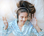 Woman, headphones and music, listening in bed to relax at home, podcast or radio streaming, peace and satisfaction. Young, wellness and positivity in bedroom, mindset and self care listen and freedom