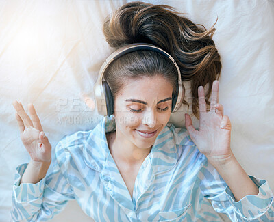 Buy stock photo Woman, headphones and music, listening in bed to relax at home, podcast or radio streaming, peace and satisfaction. Young, wellness and positivity in bedroom, mindset and self care listen and freedom