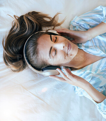 Buy stock photo Top view, woman and headphones in bedroom, morning and relax with mental health podcast, mindfulness audio and zen music. Face of happy, calm and peaceful girl listening to radio, sound and wellness 