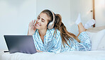 Woman, headphones and relax on laptop in bedroom to download movies, online show and media entertainment at home. Happy young female, music and computer for streaming subscription, podcast and audio