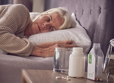 Elderly woman, bed and medical addiction with pills, medicine or medication while lying awake at home. Senior female suffering from sick, illness or mental health, trauma or disorder in the bedroom