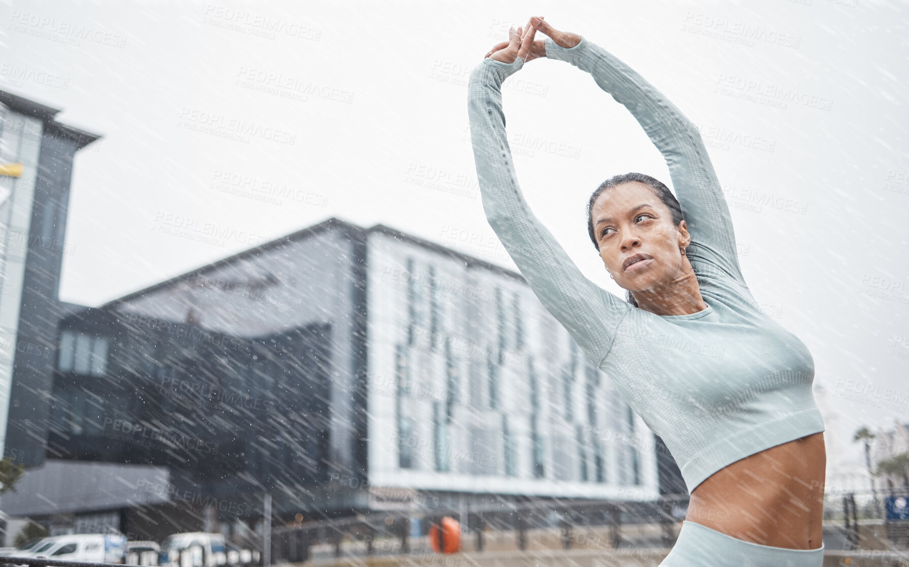 Buy stock photo Black woman, stretching and fitness in rain and city for running training for a marathon. Workout, exercise and run goal motivation of a woman athlete and runner doing sports in winter health warm up