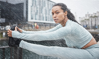 Fitness, rain or black woman stretching in city of London to start running exercise, workout or cardio training. Portrait, mindset or healthy girl athlete runner in sports warm up on a street or road