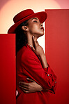 Fashion, model and black woman in studio for creative, clothes and posing in power suit on red background. Fashion model, girl and elegant clothing by designer with vision, classic and sexy aesthetic