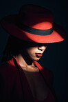 Fashion, red suit and woman in the dark for vintage clothes, retro and mafia aesthetic on a black studio background. Designer, mysterious and face of an elegant model with classy and fancy style