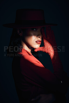 Dark, woman and spotlight with a model black woman in studio on a black background for fashion. Mystery, shadow and style with an attractive young female posing at an art event or creative showcase