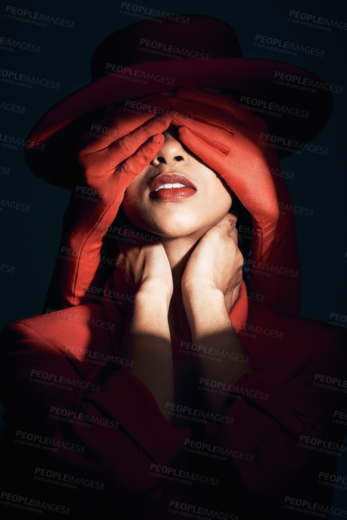 Buy stock photo Beauty, fashion and face makeup with hands over eyes of aesthetic woman with a spotlight for mystery, privacy and art deco. Red gloves hiding identity or surprise of a female model in dark studio