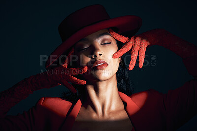 Buy stock photo Fashion, beauty and spotlight on face of woman in dark background studio makeup, cosmetics and style. Creative art, red aesthetic and girl pose with vintage, luxury outfit and designer accessories