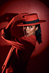 Fashion, spotlight and model with red suit, luxury clothes or designer brand apparel for aesthetic 90s style on studio background. Mystery, dark beauty or retro black woman with creative shadow light