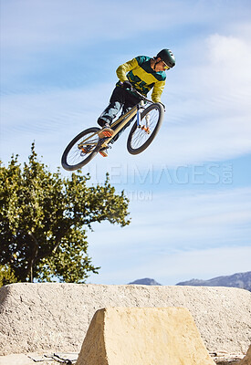 Man, cyclist and mountain biking in free style, tricks or extreme hill jumping in the nature outdoors. Professional male cycling in the mountain with bicycle in the air for freedom, parkour or sports