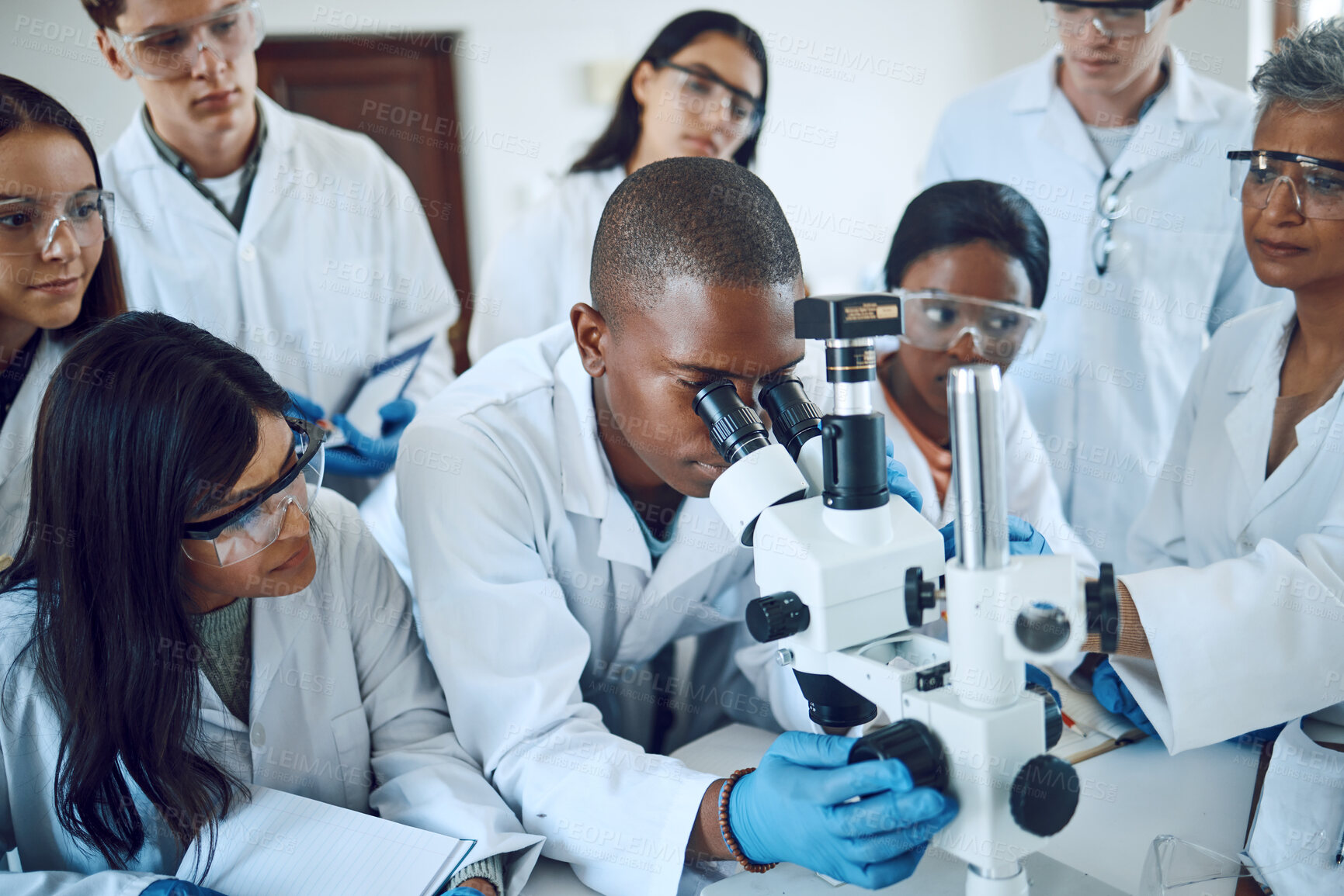 Buy stock photo Teamwork, collaboration and group of scientists with microscope for experiment. Science, laboratory and team of people or doctors with books and equipment for medical research, analysis and testing.