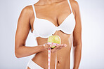 Apple, tape and woman underwear in studio with diet, lose weight results and body goals for wellness, healthcare and nutrition. Fruit, nutritionist and model in lingerie with gut health and digestion