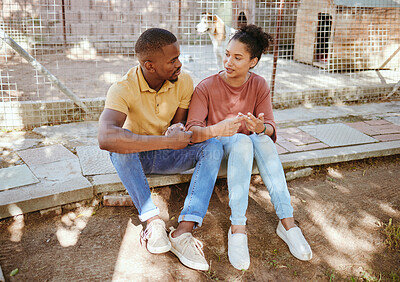 Buy stock photo Black couple, sit and love in animal shelter, homeless canine center or foster care kennel in adoption decision choice. Talking, black woman and bonding man in pet dog charity or volunteer community