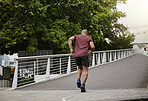 Fitness, running and man on a bridge for training, wellness and cardio in a city, cardio and energy. Sports, runner and male exercise on a highway for run, challenge and body performance goals 