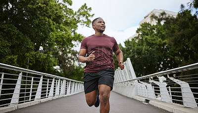 Buy stock photo Fitness, exercise and black man running in city for health and wellness. Sports, runner or young male from Nigeria jog, exercising and cardio workout outdoors on bridge training for marathon practice