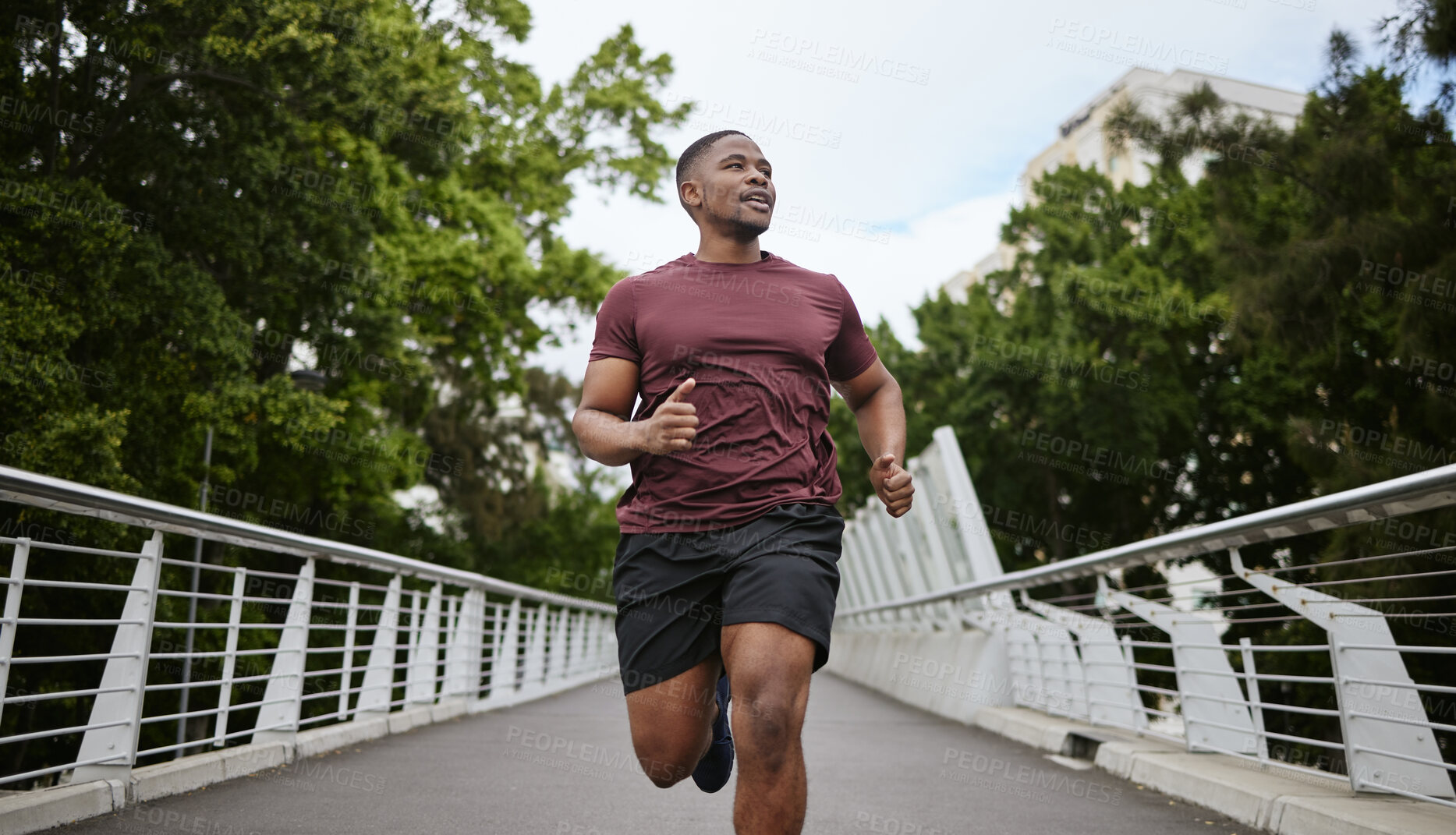 Buy stock photo Fitness, exercise and black man running in city for health and wellness. Sports, runner or young male from Nigeria jog, exercising and cardio workout outdoors on bridge training for marathon practice