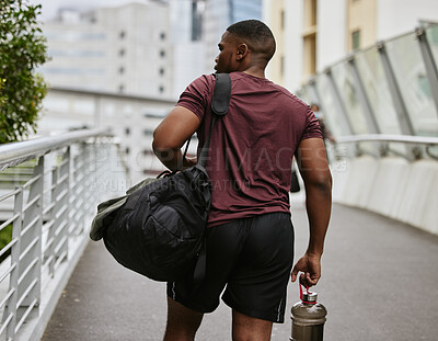 Buy stock photo Black man, back or fitness bag on city bridge, road or street with workout gear, training water bottle or exercise kit. Runner, sports athlete or personal trainer in urban travel to gym for wellness