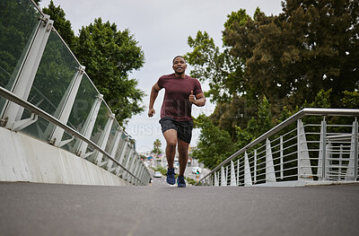 Buy stock photo Black man running on bridge in city for fitness, exercise and healthy goals, sports wellness and marathon workout. Urban runner, cardio and training to lose weight with power, action and motivation 