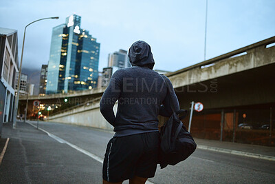 Buy stock photo Fitness, running and city with a sports man walking on an asphalt road during an exercise workout. Health, wellness and training with a male runner or athlete in an urban town during the evening