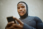 Fitness, black man and phone typing in city to check social media, internet or search mobile app, online sports blog and exercise tech. Young athlete reading notification on smartphone before workout