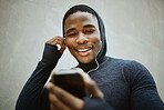 Music, phone and man against a wall in city for fitness, running and training with podcast, audio and wellness track. Radio, black man and smartphone for for listening to playlist before a workout  