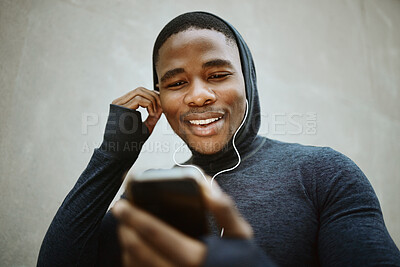 Buy stock photo Music, phone and man against a wall in city for fitness, running and training with podcast, audio and wellness track. Radio, black man and smartphone for for listening to playlist before a workout  