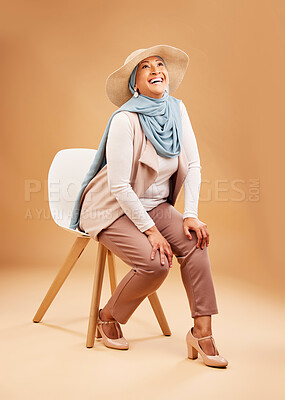 Muslim woman, fashion scarf or chair in studio background in Dubai stylish,  trendy hats or cool arabic clothes. Happy smile, laughing or mature Islamic  model on furniture seat with hijab fabric scarf |