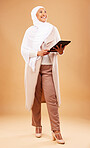 Fashion, muslim and woman with tablet in studio isolated on a brown background mock up. Technology, touchscreen and mature Islamic female thinking of internet browsing, social media or web scrolling.