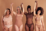Beauty, diversity and natural with woman friends in studio on a beige background with their hands raised in celebration. Wellness, underwear and real with a model female group standing together