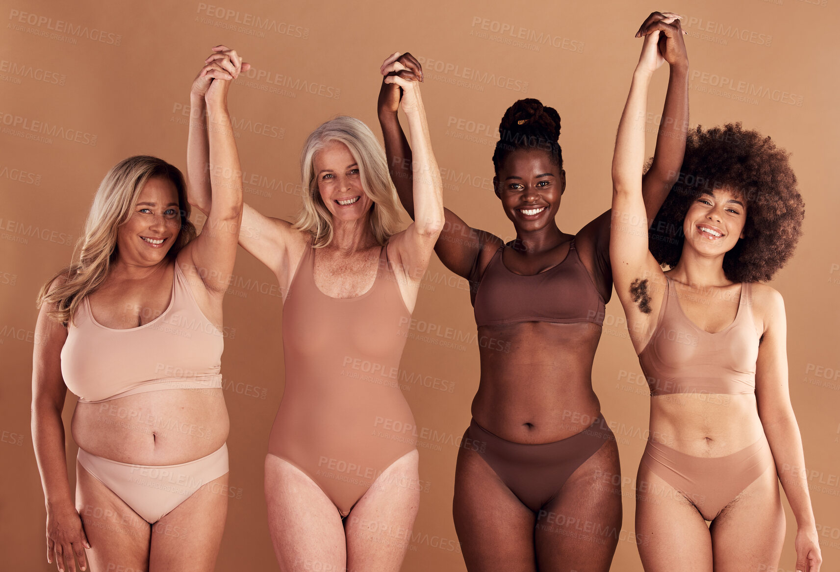 Buy stock photo Beauty, diversity and natural with woman friends in studio on a beige background with their hands raised in celebration. Wellness, underwear and real with a model female group standing together