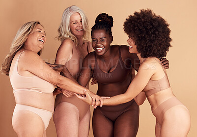 Buy stock photo Beauty, diversity and group of women in lingerie in studio isolated on brown background. Underwear, friends and body positive females, self love and holding hands for empowerment, laughing or smiling