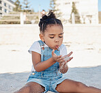 Play, child or girl in sand at a beach for fun summer holidays, vacation or weekend alone relaxing with freedom. Travel, nature or young kid toddler playing on seashore outdoors in Sao Paulo, Brazil