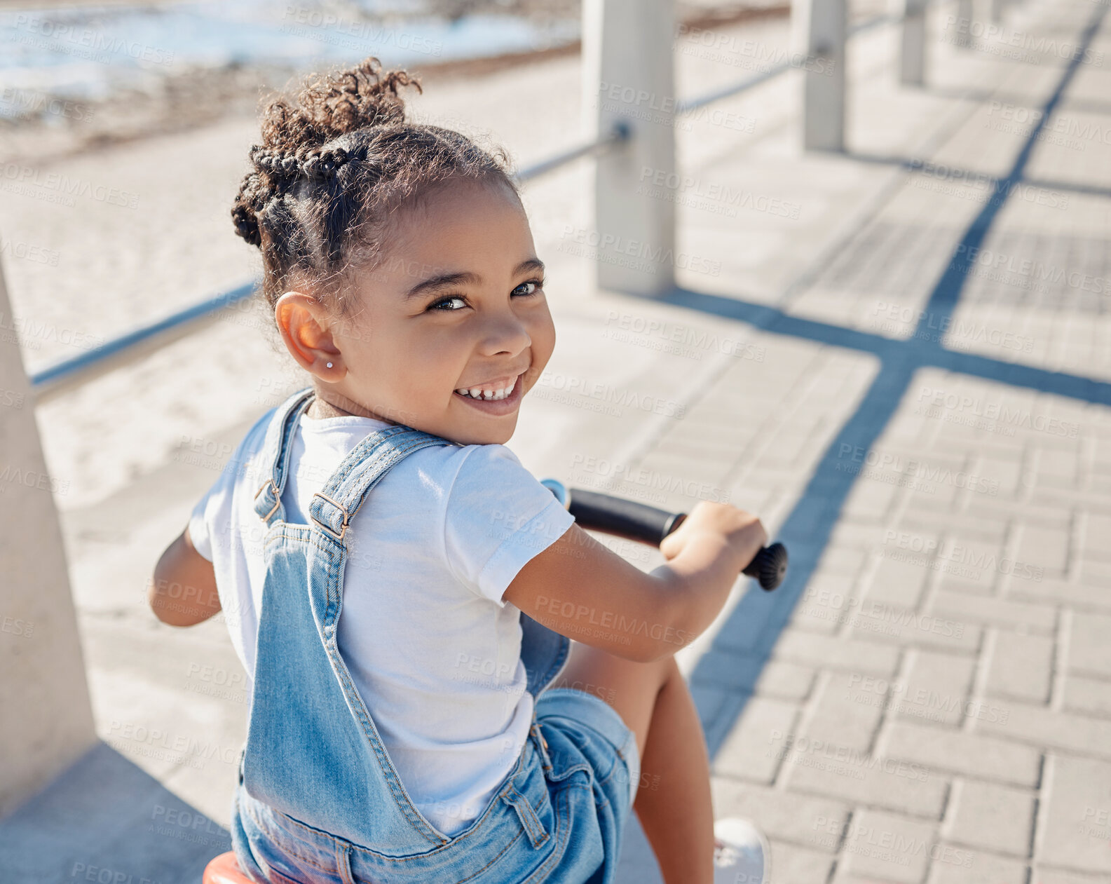 Buy stock photo Bike, girl and smile for beach, holiday and outdoor to relax, summer and waterfront. Portrait, cycling and female child enjoy seaside vacation, happy and bicycle for wellness, health and promenade.