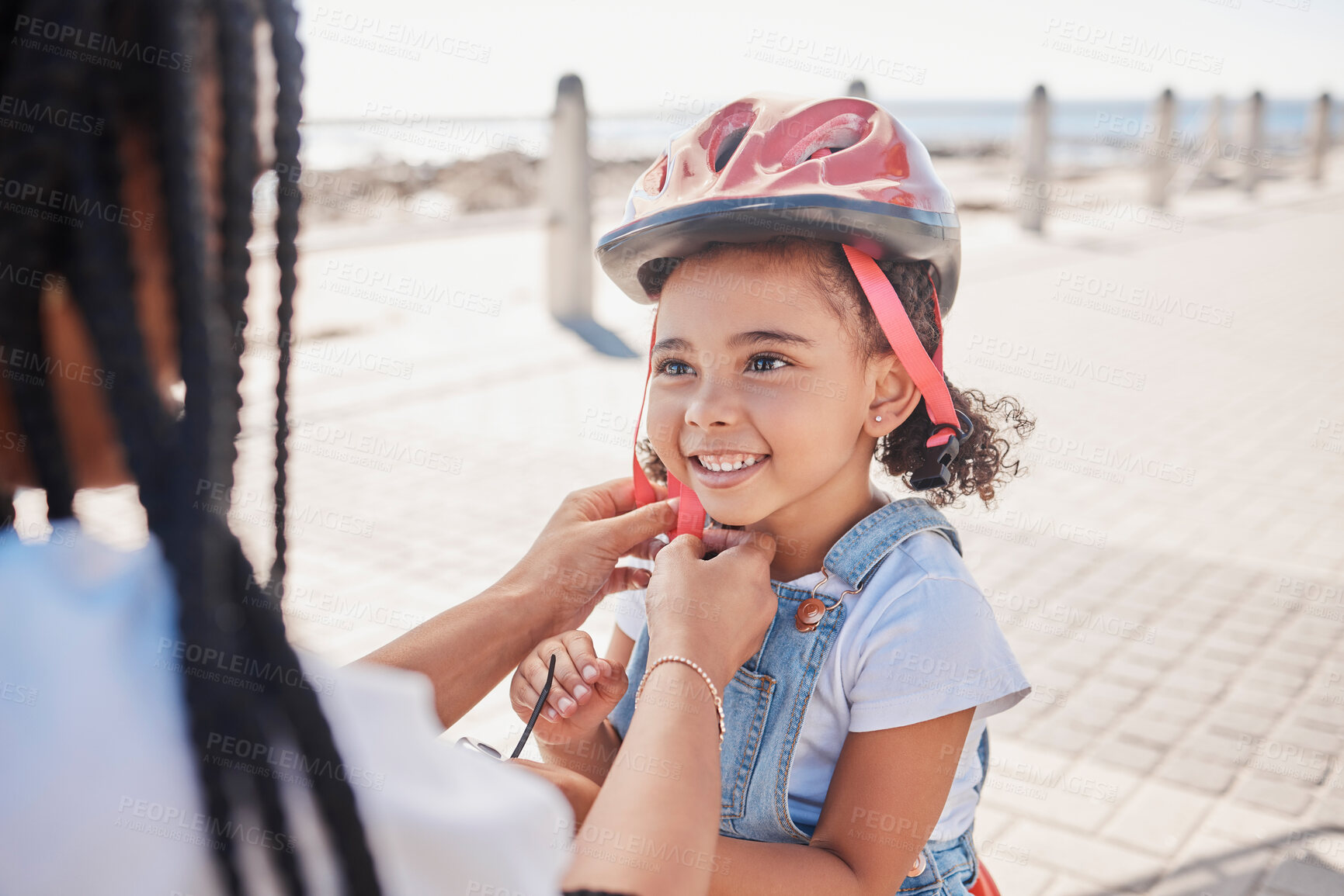 Buy stock photo Mother, child and helmet for bicycle, park and help with love, bonding and happiness by ocean in summer. Black woman, child and bike safety for learning, cycling and happy by ocean on family vacation