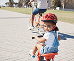 Happy, portrait or child cycling on bike learning to ride outdoors for exercise or learning development. Safety, smile or excited young girl riding a bicycle on city sidewalk path in California, USA