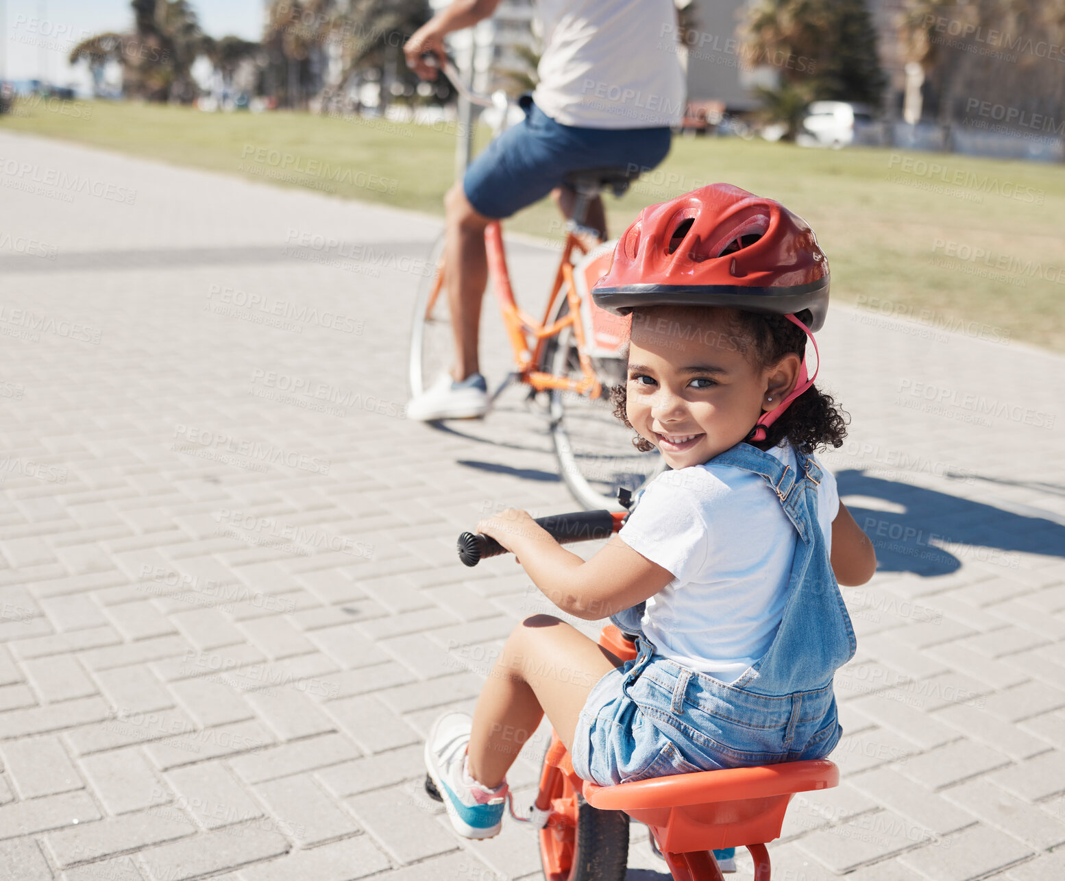 Buy stock photo Happy, portrait or child cycling on bike learning to ride outdoors for exercise or learning development. Safety, smile or excited young girl riding a bicycle on city sidewalk path in California, USA