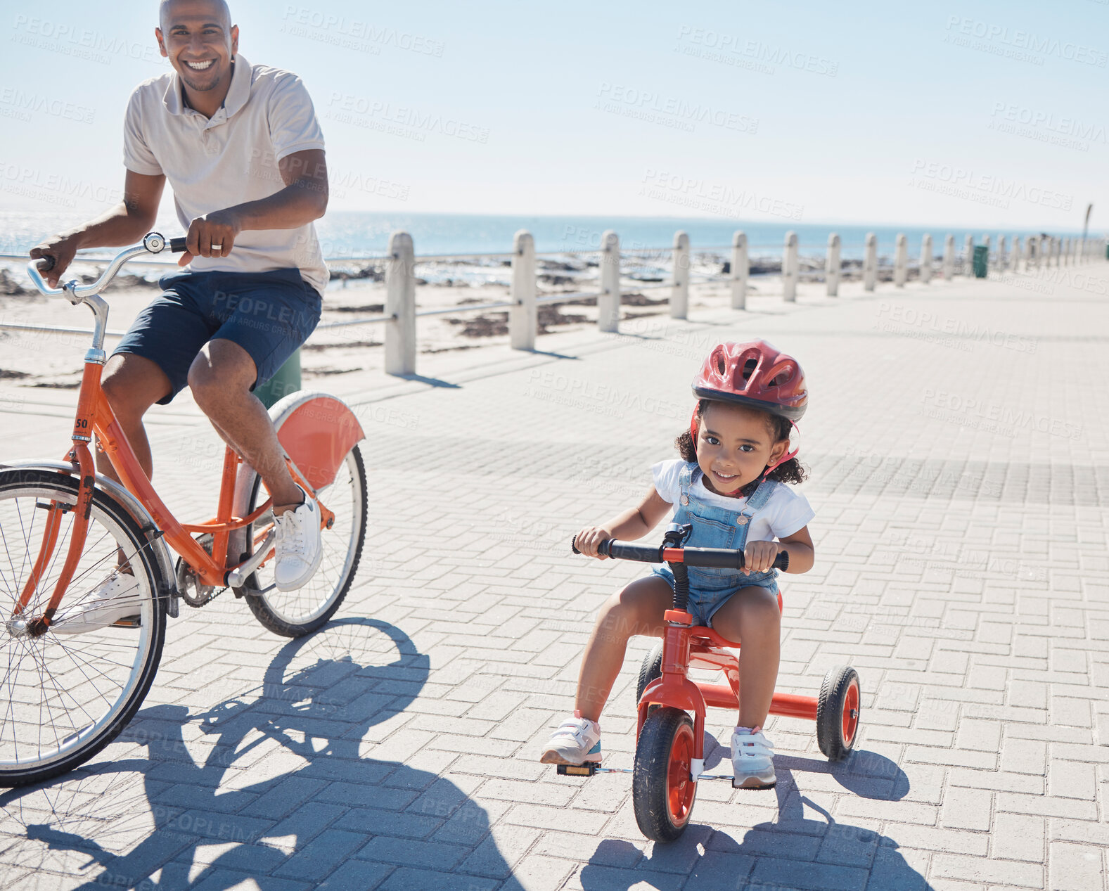 Buy stock photo Family, portrait and cycling at the beach with girl and father on bicycle, happy and smile while learning, bond and having fun. Happy family, bike and parent with child at the sea for ride in nature