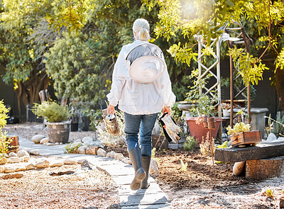 Buy stock photo Beekeeping, smoke for bees and woman in garden walking with farming equipment, gear and protective suit. Agriculture, nature and senior lady ready to harvest natural, organic and fresh honeycomb