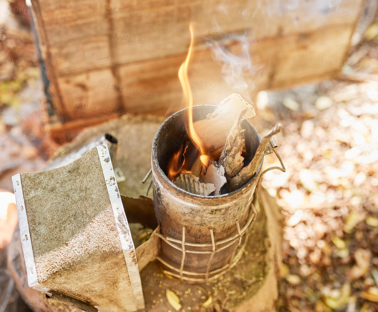 Buy stock photo Smoke, fire and metal container on bee farm for agriculture, smoking and honey production. Farming, vintage and beekeeping with flame in smoker to calm bees for safety, protection and preparation 