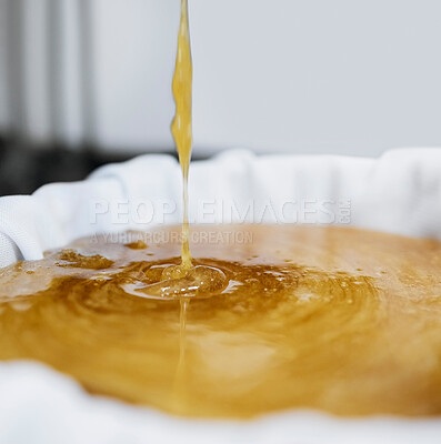 Buy stock photo Honey production, extraction and drip in factory with sweet gold, splash and filter cloth in container. Honeycomb harvest, manufacturing and process with machine, liquid and beekeeping in California