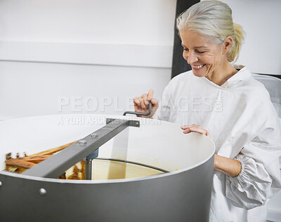 Buy stock photo Woman, beekeeper and machine for honey production at factory. Agro sustainability, agriculture and mature female bee farmer with mixer in warehouse for manufacturing or harvesting organic propolis.